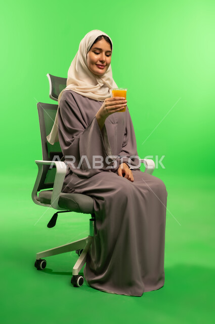 Saudi Woman with Orange Juice on Green Screen Background