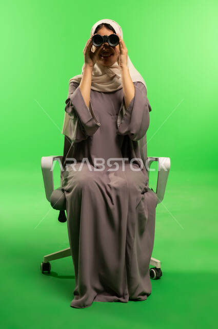 Saudi Woman with Binoculars on Green Screen Background