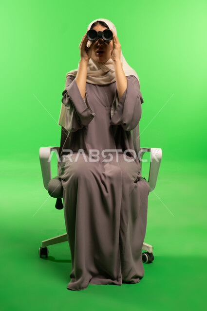 Saudi Woman Using Binoculars on Green Screen Background