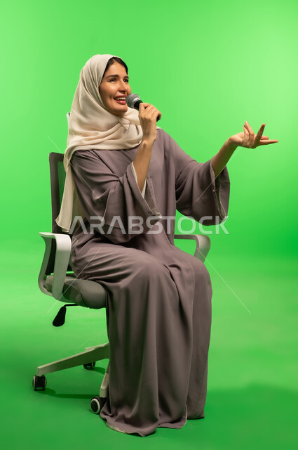 Saudi Woman with Microphone on Green Screen Background