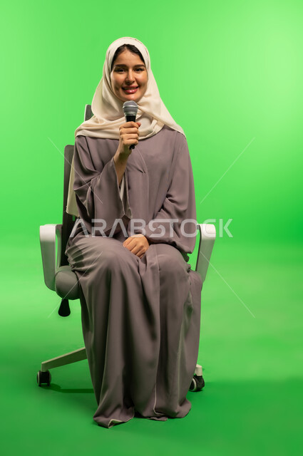 Saudi Woman with Microphone on Green Screen Background