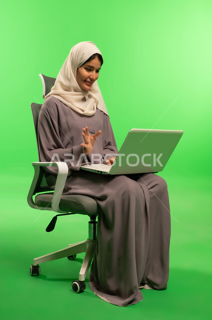 Saudi Woman Using Laptop on Green Screen Office Chair