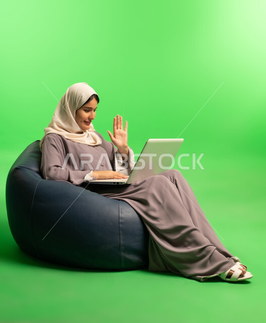 امرأة سعودية تستخدم الحاسوب المحمول خلفية خضراء