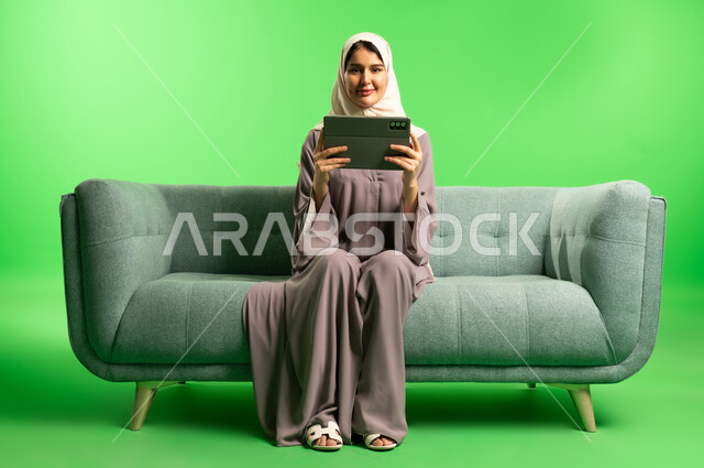 Saudi Woman Using Tablet on Sofa Green Screen