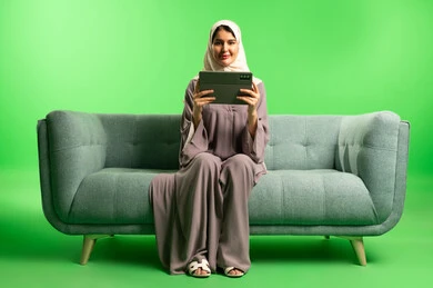 Saudi Woman Using Tablet on Sofa Green Screen