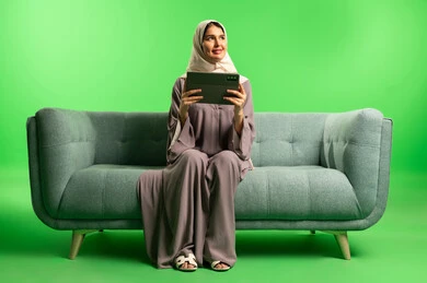 Saudi Woman with Tablet on Green Screen Sofa
