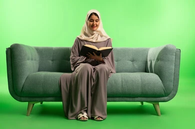 Saudi Woman Reading Book on Sofa Green Screen
