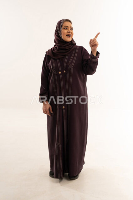 Saudi Woman in Abaya Pointing Up in Studio