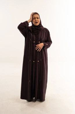 امرأة سعودية بالعباءة تعبر عن الألم والتعب