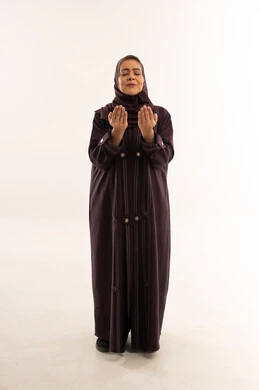 Saudi Woman in Abaya Praying on White Background