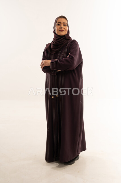 امرأة سعودية بعباءة أرجوانية أمام خلفية بيضاء