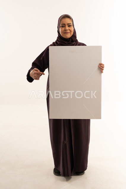 Saudi Woman Holding Blank White Poster in Studio