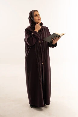 امرأة عربية بالعباءة تقرأ كتاباً بخلفية بيضاء