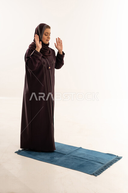 امرأة مسلمة تؤدي الصلاة على خلفية بيضاء