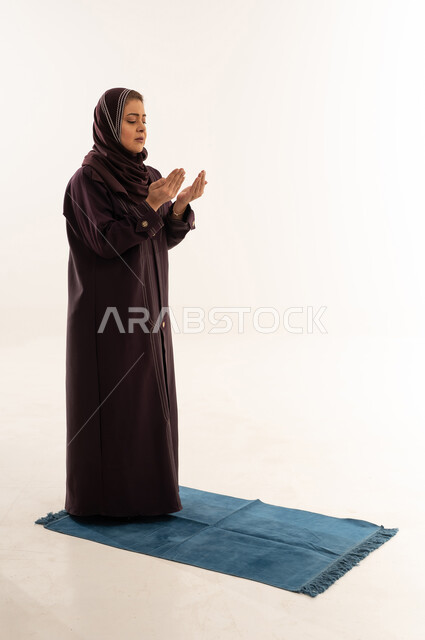 امرأة مسلمة تدعو الله على سجادة الصلاة