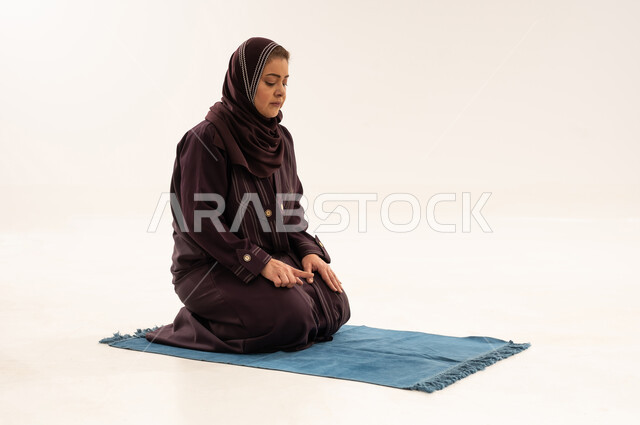 Saudi Woman Performing Tashahhud Prayer on White Background