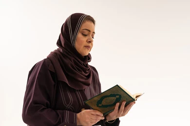 امرأة عربية تقرأ القرآن الكريم في الاستوديو
