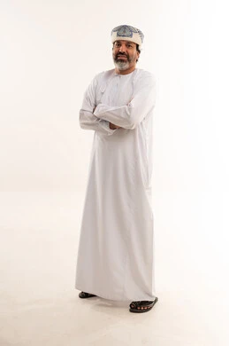 رجل عُماني بالدشداشة التقليدية على خلفية بيضاء