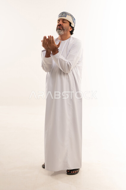 Omani Man in Traditional Dress Praying in Studio