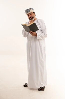 Omani Man in Traditional Dress Reading Book