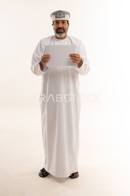 Omani Man Holding Blank White Paper in Studio