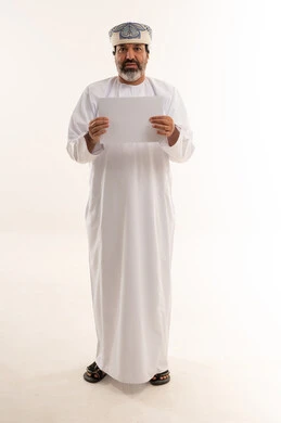 رجل عُماني يمسك ورقة بيضاء فارغة في استوديو