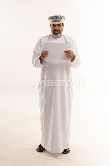 Omani Man in Traditional Dress Holding Blank White Paper