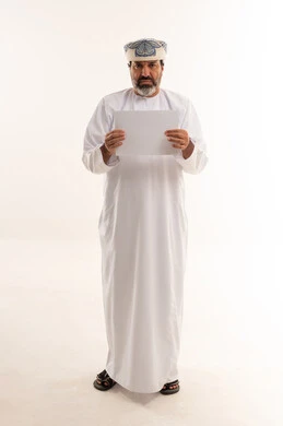 رجل عماني بالزي التقليدي يحمل ورقة بيضاء فارغة