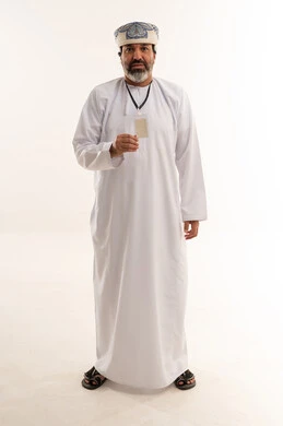 رجل عماني بالزي التقليدي يحمل بطاقة تعريفية