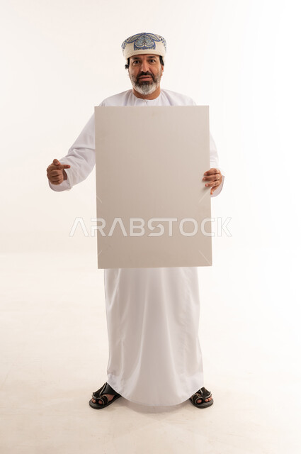 Omani Man Holding Blank White Board in Studio Background