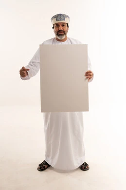 رجل عماني يحمل لوحة بيضاء فارغة في الاستوديو