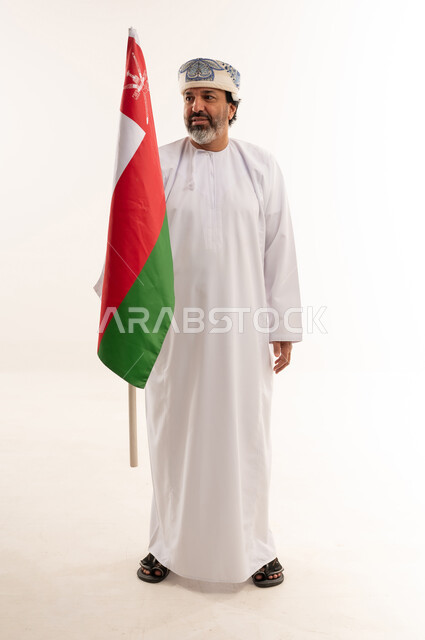 Omani Man in Traditional Dress Holding Oman Flag