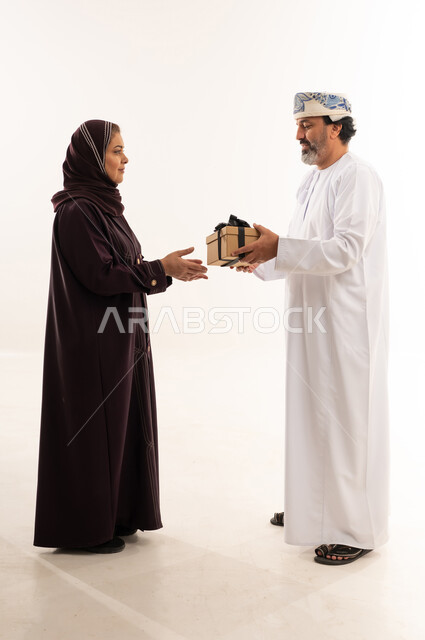 Omani Couple Exchanging Gift Box on White Background