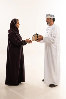 رجل وامرأة من عمان يتبادلان الهدايا في استوديو
