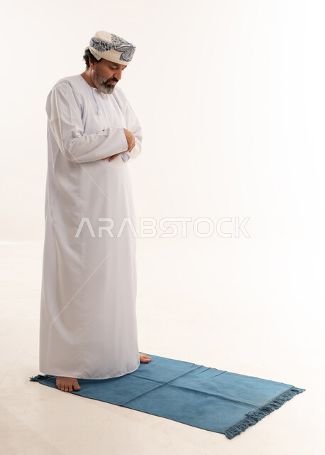 رجل عماني بالزي التقليدي يؤدي الصلاة