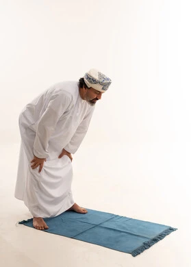 رجل عماني يؤدي وضعية الركوع في الصلاة