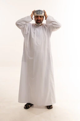 رجل عُماني بزي تقليدي يشعر بالتوتر على خلفية بيضاء