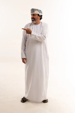 Smiling Omani Man in Traditional Dress Pointing in Studio