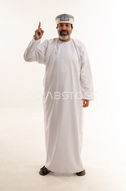 Omani Man in Traditional Dress Pointing Upward