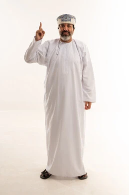 رجل عماني بالزي التقليدي يشير إلى الأعلى