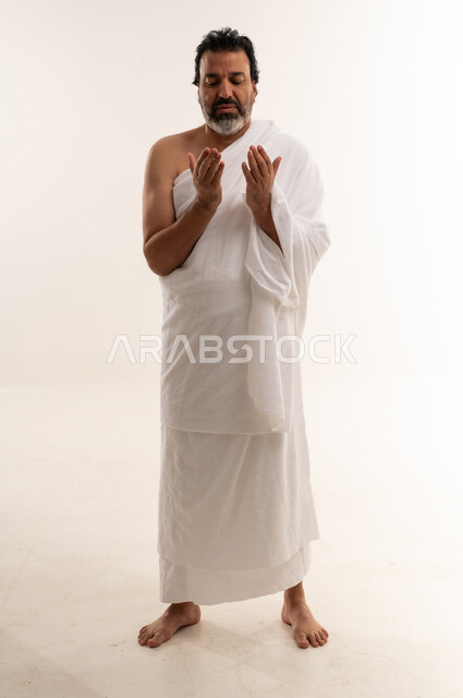 Arab Man in White Ihram Praying on White Background