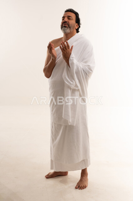 رجل عربي بملابس الإحرام يدعو في الحج والعمرة