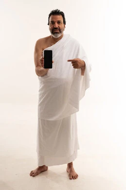 Saudi Pilgrim in Ihram Pointing at Smartphone Screen
