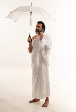 Arab Man in Ihram with Umbrella and Smartphone