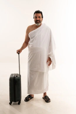 حاج عربي بملابس الإحرام وحقيبة سفر للحج والعمرة