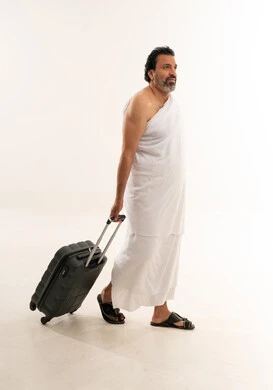 Arab Pilgrim in Ihram Walking with Suitcase