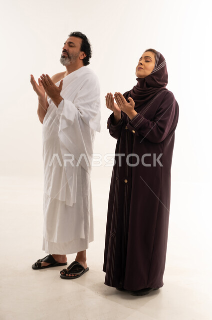 Muslim Couple in Ihram Praying on White Background