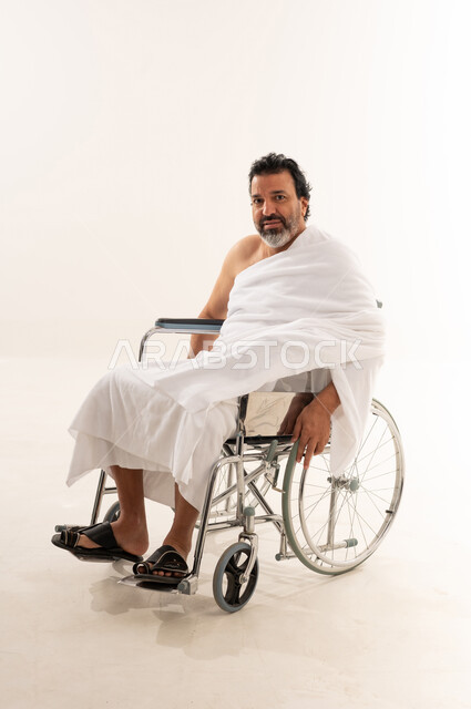 حاج عربي على كرسي متحرك مع خلفية بيضاء