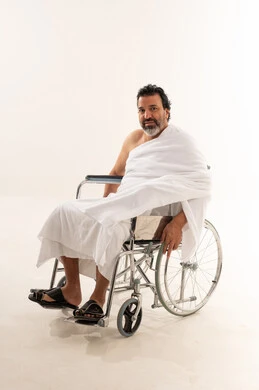 حاج عربي على كرسي متحرك مع خلفية بيضاء