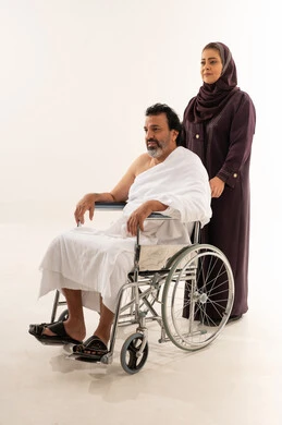 حاج عربي على كرسي متحرك بملابس الإحرام